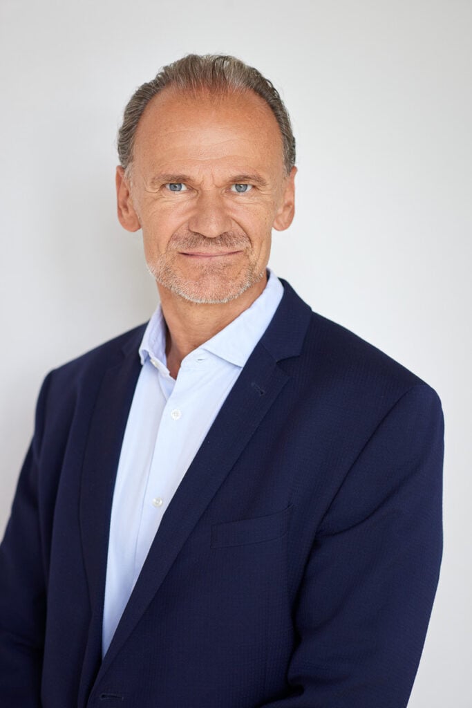 Modernes Business Portrait eines Mannes vor hellem Hintergrund in München.