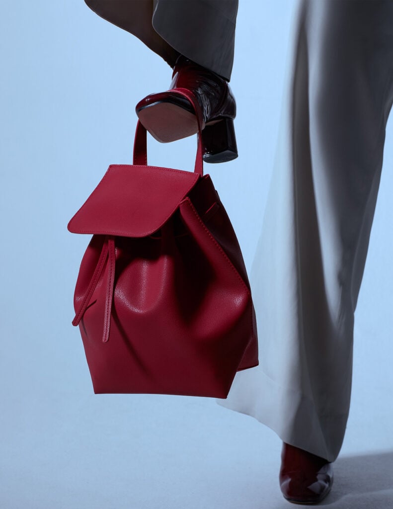 Kampagnenfoto in München: Fashion-Detail mit roter Tasche in Bewegung, clean und hochwertig inszeniert.