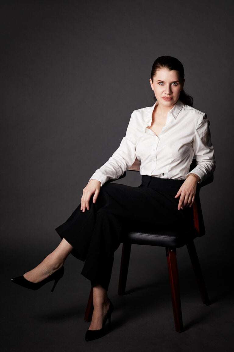 Modernes Business Portrait einer Frau, sitzend, dunkler Hintergrund, München