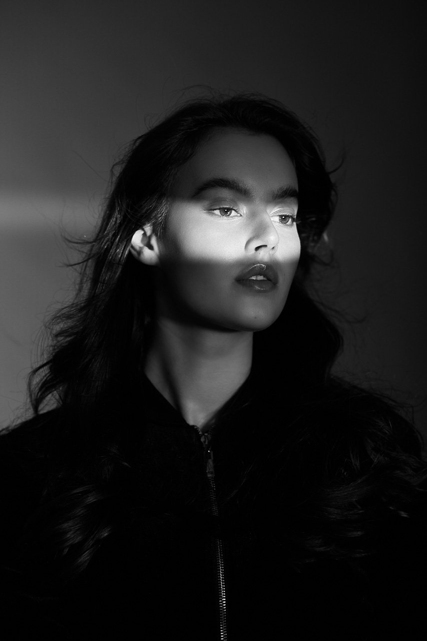 Schwarzweiß-Portrait einer Frau mit Lichtstreifen, aufgenommen im Studio von Francesco Rizzato in München.